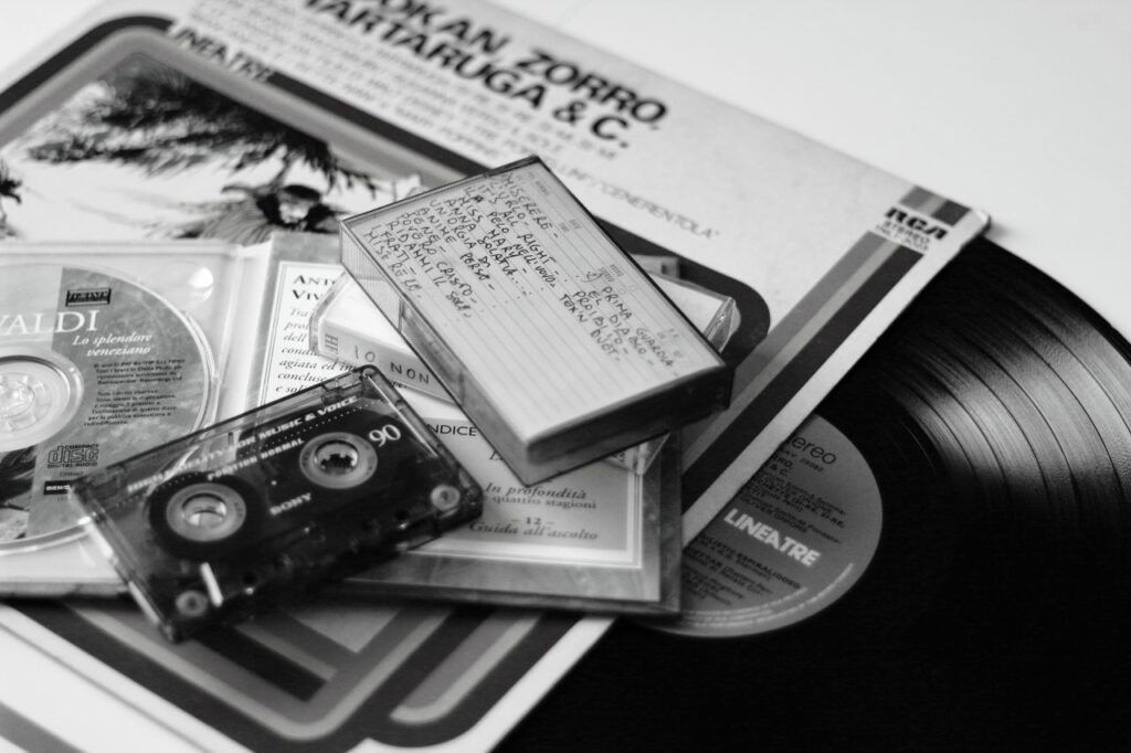 A creative display of retro audio formats including vinyl, cassette, and CD.
